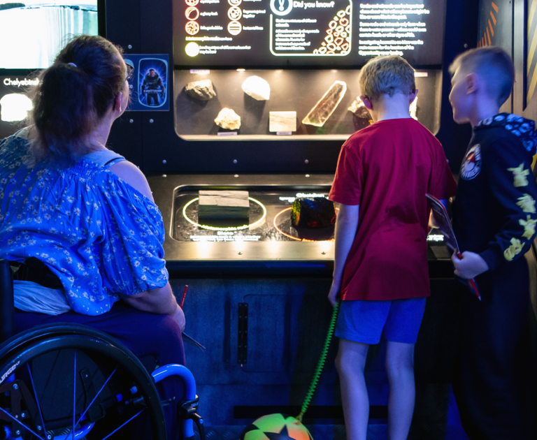 Mother with her two children in Explorer:Space. The mother is in a wheelchair.