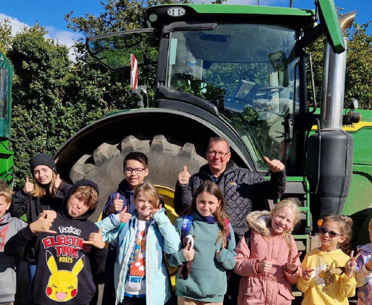 The Young Design Panel are stood in front of a tractor.