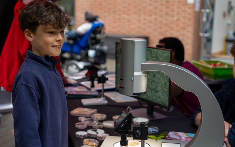 Boy smiling by a microscope