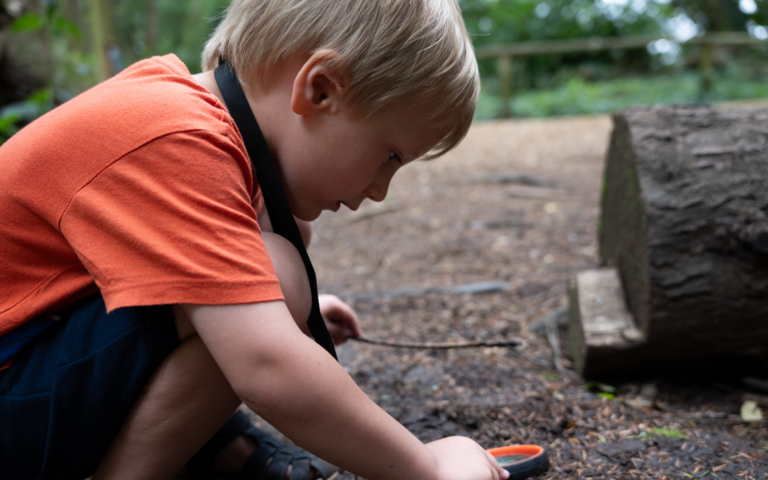 Child using magnifying glass.