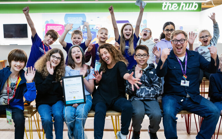 A group of children celebrate winning an award certificate